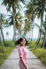 asian woman portrait in the summer day. happy enjoy carefree female outdoor with tropical coconut trees