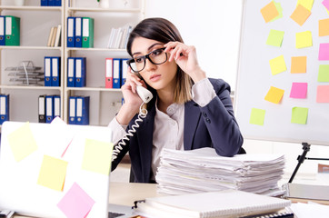 Young female employee in conflicting priorities concept