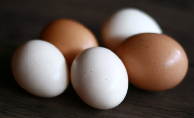Chicken eggs (brown) and kampong chicken eggs (white) on wood background. Description