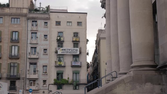 BARCELONA, SPAIN - FEBRUARY 2019. Quarter in Barcelona with a balcony on which are hung the flag of Catalonia and the yellow ribbon and protest poster. The concept of separatism and detachment from