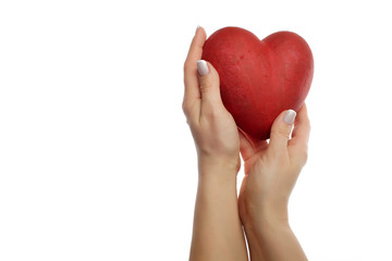 Hands of young woman holding red heart on white background