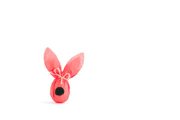 Fototapeta na wymiar Easter bunny gift egg wrapped in coral craft paper isolated on white background.