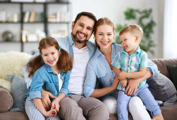 happy family mother father and kids at home on couch.