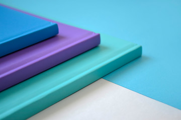 stack of multicolored books on a neutral background