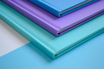 stack of multicolored books on a neutral background