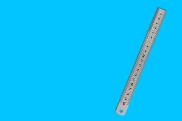 Single metal straightedge with digits and scale on blue background with copy space for your text
