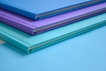 stack of multicolored books on a neutral background