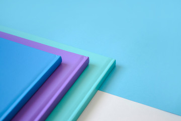 stack of multicolored books on a neutral background