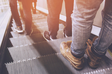 close up legs shoes people crowd using escalator electronic system moving. vintage filter....