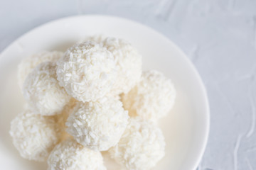 Fototapeta na wymiar Round, white candies in coconut flakes