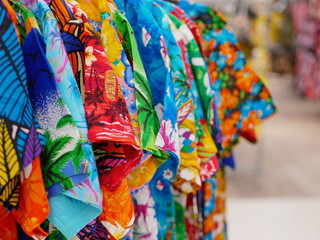 Selective focus of vivid colorful t-shirts on hangers for sale in a shopping mall