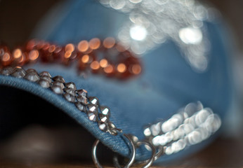 Denim cap with rhinestones and metal rings with a blurred background and bokeh