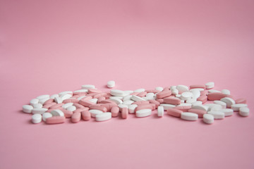 lots of pink and white pills on a pink background