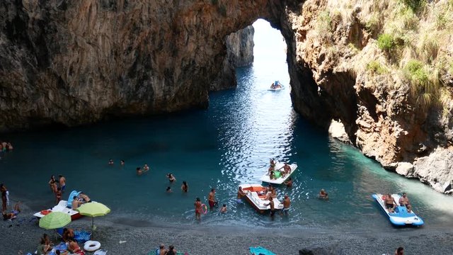 San Nicola Arcella, Cosenza, Calabria, Italy - September 6 2018: bathers in Arcomagno (Arco magno) at sunset, beautiful Italian beach and natural arch on Mediterranean sea (Tyrrhenian)
