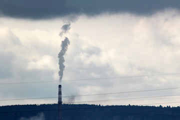 Thick smoke from the factory chimney against the blue sky