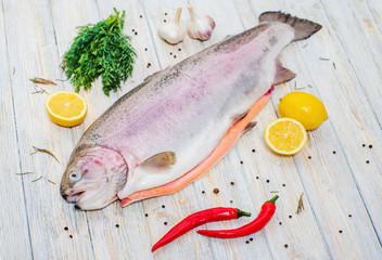 Big fresh trout on the table with lemon and spices