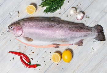 Big fresh trout on the table with lemon and spices