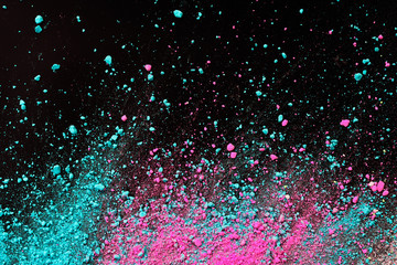 A splatter of pastel natural colored pigment powder on black background.
