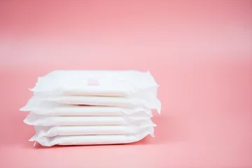 Foto op Canvas Stacked sanitary napkin pad on pink background. © Suphansa