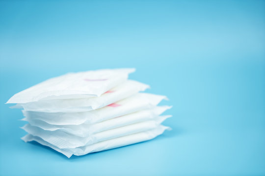 Stacked sanitary napkin pad on blue background.