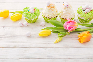 Easter cupcakes on white wooden table