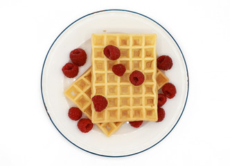 fresh belgian waffles with raspberrys on a plate isolated on white background