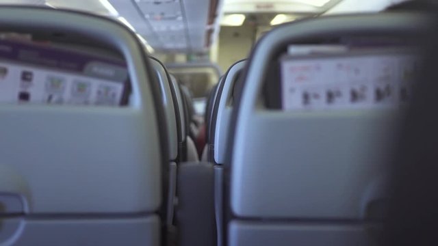 Passengers chairs inside cabin modern airplane while flying in sky. Passengers seats in economy class commercial plane while flight. People traveling by commercial airplane.