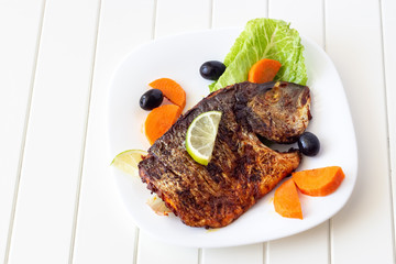 Grilled fish sea bream with vegetables on white plate. White background. Healthy diet food concept.
