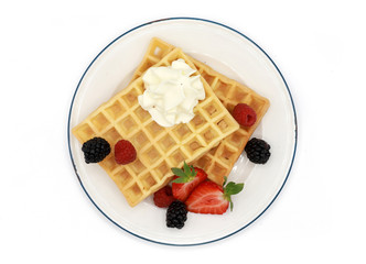 fresh belgian waffles with strawberries, raspberrys, blackberries  and whipped cream on a plate...
