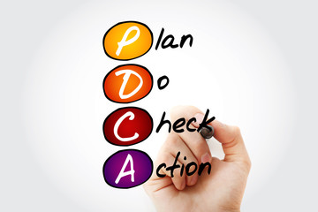 Hand writing PDCA - Plan Do Check Action with marker, acronym concept background
