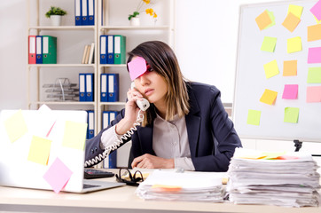 Young female employee in conflicting priorities concept