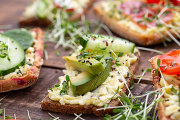 Sandwiches with cream cheese, vegetables and salami.