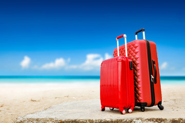 Summer red suitcase on beach and sea landscape. Free space for your decoration. Summer time 