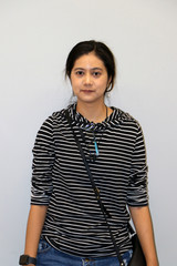 Asian modern woman in white and black stripes color of long-sleeved T-shirt on grey background.