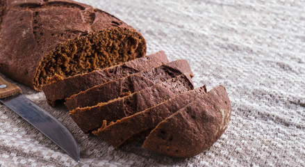 Sliced rye bread with knife.  Freshly dark bread with copy space. Toned photo