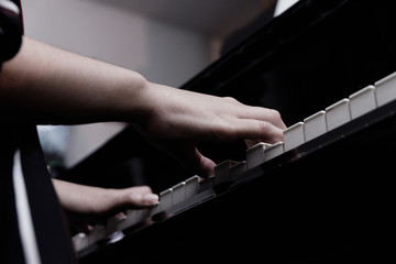 close-up female hand playing grand piano.