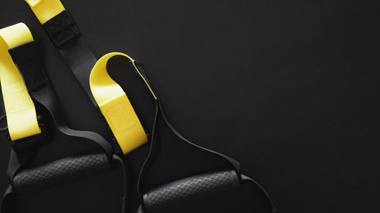 Black and yellow strap functional training equipment on grey background. Sport accessories. Fitness...