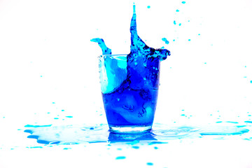 Blue water splash in glass isolated on white background