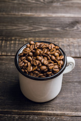 Metal cup full of coffee beans. Selective focus. Shallow depth of field.