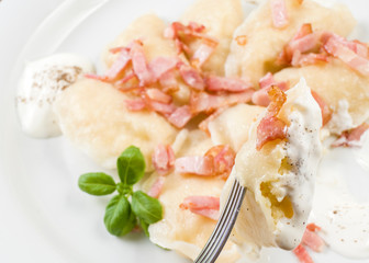 Cooked dumplings with cheese pork scratching and creme fraiche