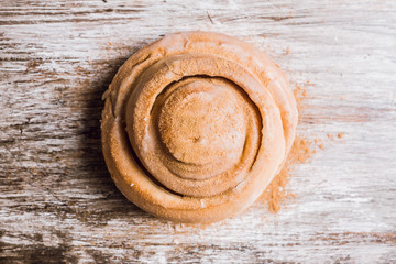 Cinnamon bun on the wooden background. Selective focus.
