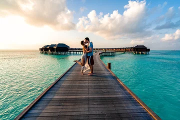 Fotobehang A couple enjoying a sunrise in the Maldives.   © nick