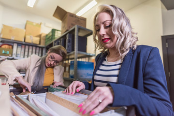 wide angle of attractive office woman working looking files in basement