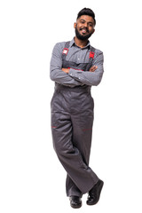 Fototapeta premium Portrait of cheerful indian repairer in shirt and overall having arms crossed looking at camera isolated on grey background