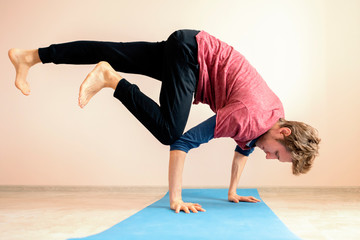young man doing very difficult advanced yoga asana position balance f