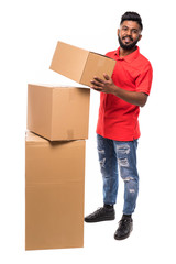 Full length side view of indian delivery man carrying cardboard box on white background