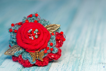 red boho brooch on wooden table