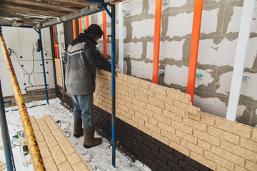 Installing brick siding on the wall of the house