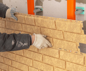 Installing brick siding on the wall of the house