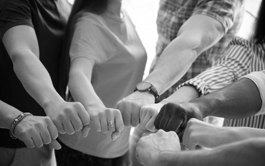 People putting hands together indoors. Unity concept